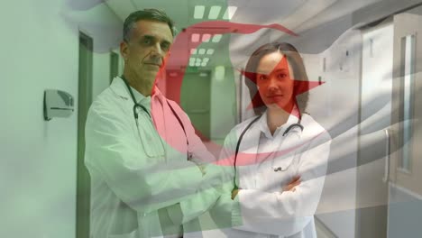 Animation-of-flag-of-algeria-over-diverse-doctors-with-arms-crossed