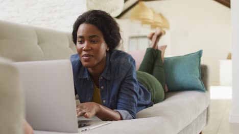 Video-Einer-Glücklichen-Afroamerikanischen-Frau-Auf-Dem-Sofa,-Die-Laptop-Benutzt