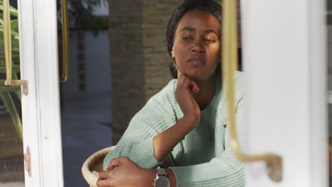 Video-Einer-Traurigen-Afroamerikanischen-Frau,-Die-Aus-Dem-Fenster-Schaut
