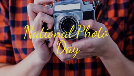 Animation-of-caucasian-man-holding-camera-over-national-photo-day-text