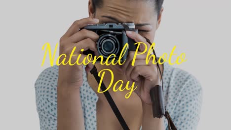 Animation-of-caucasian-woman-holding-camera-over-national-photo-day-text