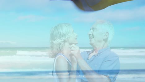 Animation-of-landscape-with-ocean-over-happy-senior-caucasian-couple-dancing-at-beach