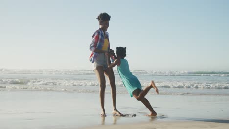 Glückliche-Afroamerikanische-Mutter,-Die-Mit-Ihrer-Tochter-Am-Sonnigen-Strand-Spielt