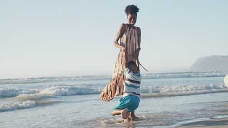 Glückliches-Afroamerikanisches-Paar,-Das-Mit-Tochter-Und-Sohn-Am-Sonnigen-Strand-Spielt