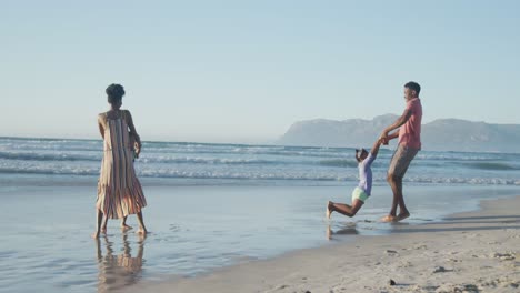 Glückliches-Afroamerikanisches-Paar,-Das-Mit-Tochter-Und-Sohn-Am-Sonnigen-Strand-Spielt