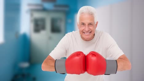 Animation-of-happy-senior-caucasian-man-with-boxing-gloves-over-gym