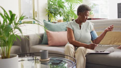 Senior-african-american-woman-measuring-pressure-alone-at-home