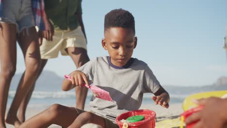 Afroamerikanischer-Junge,-Der-Im-Sand-Am-Strand-Spielt