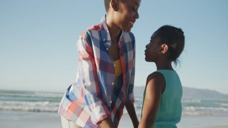 African-american-mother-and-daughter-hugging-each-other-at-the-beach