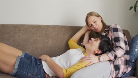 Caucasian-woman-lying-on-the-lap-of-her-wife-on-the-couch-at-home