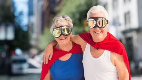 Animation-of-happy-senior-caucasian-couple-with-superhero-costumes-over-city