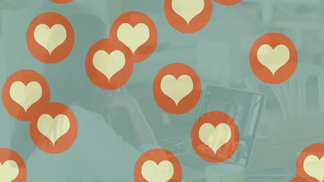 Animación-De-Iconos-De-Corazón-Sobre-Una-Mujer-Caucásica-Usando-Una-Computadora-Portátil