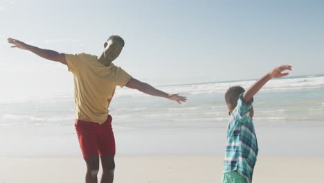 Padre-E-Hijo-Afroamericanos-Con-Los-Brazos-Abiertos-Disfrutando-En-La-Playa