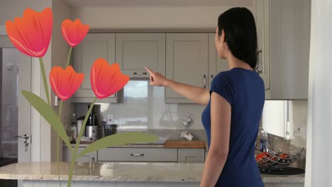 Animation-of-flower-icons-over-caucasian-woman-in-kitchen