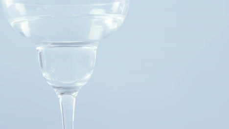Video-of-olives-falling-into-glass-of-martini-on-white-background