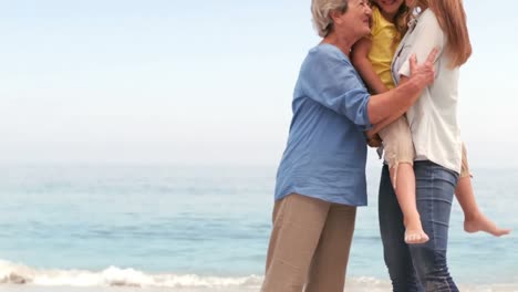 Animation-of-do-it-for-them-over-happy-caucasian-grandmother,-mother-and-daughter-on-beach