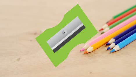 Animation-of-green-pencil-sharpener-moving-over-coloured-pencils-on-desk