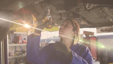 Animation-of-glowing-light-over-caucasian-female-car-mechanic-in-workshop