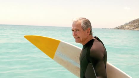 Animation-of-do-it-for-them-over-happy-caucasian-senior-male-surfer-on-beach
