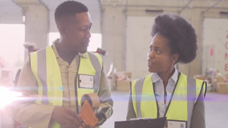 Animation-of-glowing-light-over-african-american-man-and-woman-working-in-warehouse