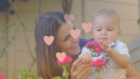 Animation-of-hearts-over-happy-caucasian-mother-holding-baby