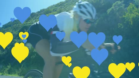 Animation-of-blue-and-yellow-hearts-over-caucasian-woman-cycling