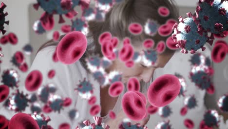 Animation-of-red-blood-and-covid-19-cells-over-caucasian-woman-coughing