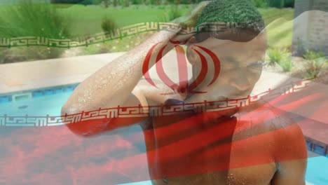 Animation-of-flag-of-iran-over-wet-african-american-man-at-swimming-pool