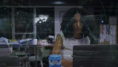 Animation-Von-Finanzdaten-über-Eine-Biraziale-Geschäftsfrau,-Die-Im-Büro-Am-Laptop-Arbeitet