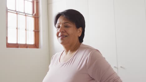 Porträt-Einer-Afroamerikanischen-Seniorin,-Die-Zu-Hause-Am-Fenster-Lächelt