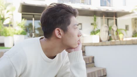 Asiatischer-Männlicher-Teenager-Sitzt-Und-Entspannt-An-Einem-Sonnigen-Tag-Im-Garten