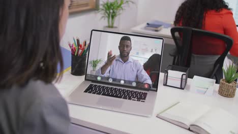 Biracial-businesswoman-using-laptop-for-video-call-with-african-american-business-colleague