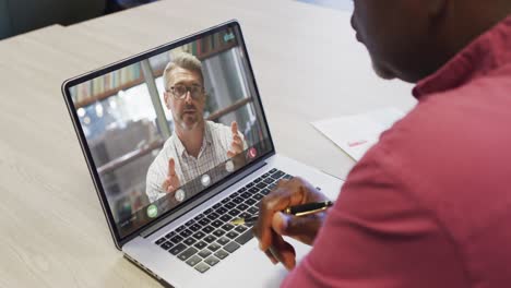 African-american-businessman-using-laptop-for-video-call-with-caucasian-business-colleague