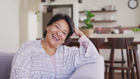 Porträt-Einer-Lächelnden-Afroamerikanischen-Seniorin,-Die-Zu-Hause-Auf-Der-Couch-Sitzt