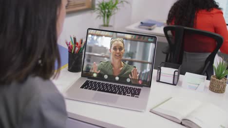 Biracial-businesswoman-using-laptop-for-video-call-with-caucasian-business-colleague