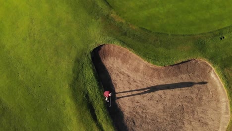 Aerial-view-of-male-golf-player-playing-golf-at-the-golf-course-on-a-bright-sunny-day