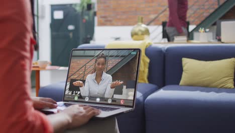 Animation-of-biracial-woman-having-video-call-on-laptop-with-biracial-female-coworker