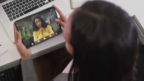 Video-of-biracial-woman-having-video-call-on-tablet-with-biracial-female-coworker