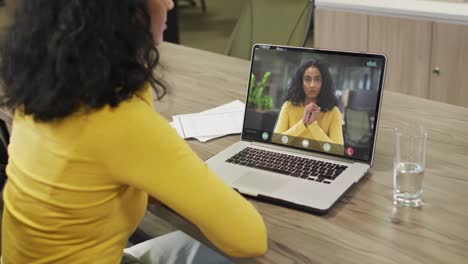 Video-of-african-american-woman-having-video-call-on-laptop-with-biracial-female-coworker