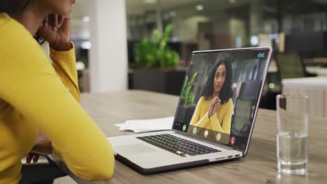 Video-Einer-Afroamerikanischen-Frau,-Die-Auf-Einem-Laptop-Einen-Videoanruf-Mit-Einer-Gemischtrassigen-Kollegin-Führt