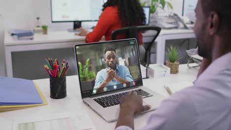 Video-Eines-Afroamerikanischen-Mannes,-Der-Auf-Einem-Laptop-Einen-Videoanruf-Mit-Einem-Männlichen-Kollegen-Führt