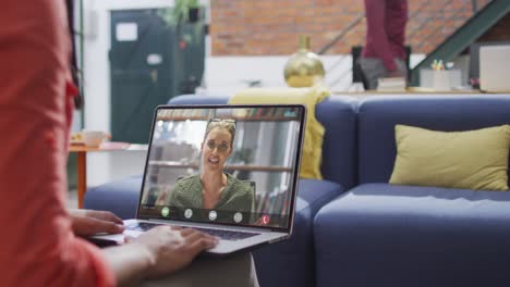 Animation-of-biracial-woman-having-video-call-on-laptop-with-caucasian-female-coworker
