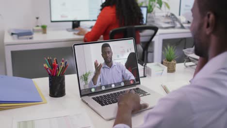 Video-of-african-american-man-having-video-call-on-laptop-with-african-american-male-coworker