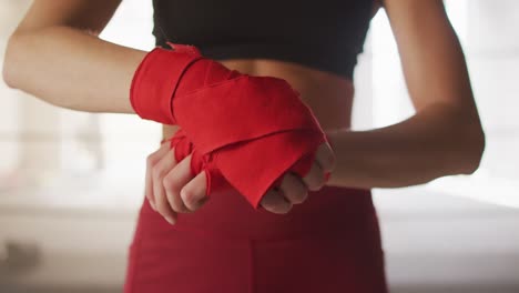 Video-Der-Hände-Einer-Kaukasischen-Frau,-Die-Bänder-Bindet-Und-Sich-Auf-Das-Boxtraining-Im-Fitnessstudio-Vorbereitet