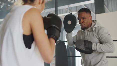Video-of-fit-diverse-woman-and-man-boxing-at-gym