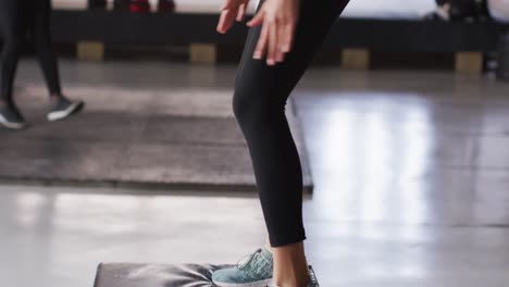 Video-Der-Beine-Einer-Fitten-Kaukasischen-Frau,-Die-Im-Fitnessstudio-Auf-Einen-Block-Springt