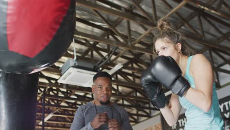 Video-of-fit-diverse-woman-and-man-boxing-at-gym
