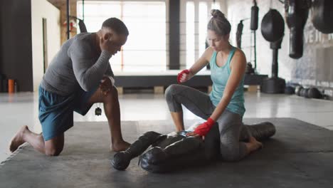 Video-of-fit-diverse-woman-and-man-preparing-for-training-at-gym