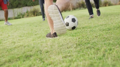 Diverse-Männliche-Freunde-Spielen-An-Sonnigen-Tagen-Im-Garten-Fußball