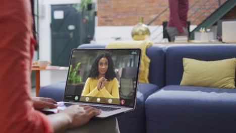 Biracial-businesswoman-using-laptop-for-video-call-with-biracial-business-colleague